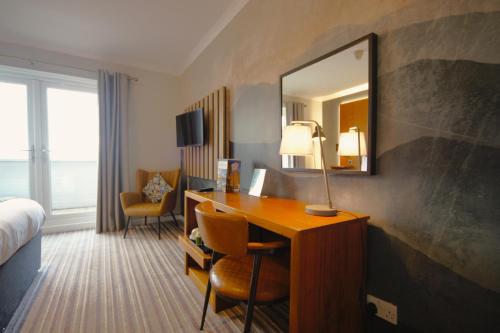a hotel room with a desk and a mirror at Highfield Hotel in Houghton le Spring