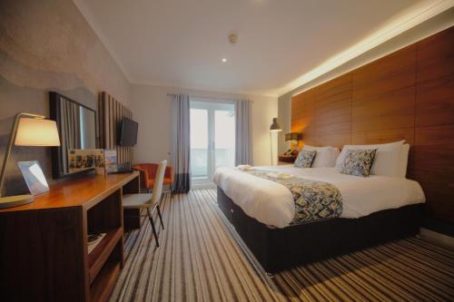 a hotel room with a bed and a desk at Highfield Hotel in Houghton le Spring