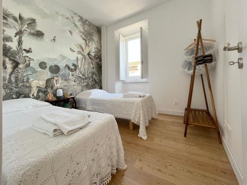 una camera con due letti e un dipinto sul muro di Casa Alta a Castelo de Vide