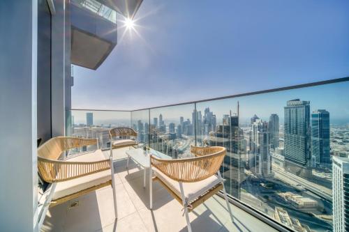 a balcony with chairs and a view of the city at Downtown Luxury - Stunning Burj Khalifa & Sea View - 5 Minutes Walk to Dubai Mall in Dubai