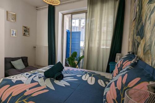 a bedroom with a bed with a blue comforter at Cosy Queen - T4 - Hyper centre & parking in Pau