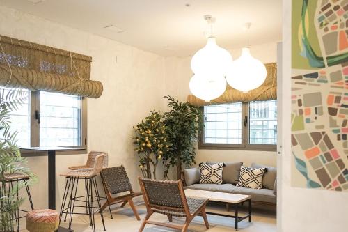 a living room with a couch and chairs and windows at Lumen Mare by SH Hoteles in Valencia