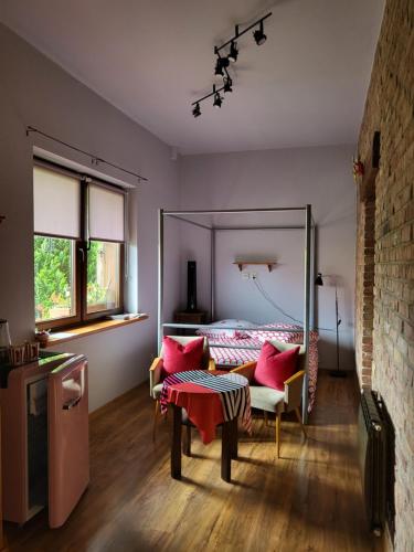 a bedroom with a bed with pink pillows and a table at DOM GOŚCINNY PTASZARNIA - NATURA-Free PARKING in Świnoujście