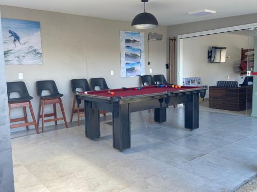 a ping pong table in a room with chairs at OPY CAMBOA in Governador Celso Ramos