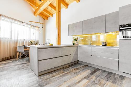 a kitchen with gray cabinets and a dining room with a table at KORZO Lipno in Lipno nad Vltavou