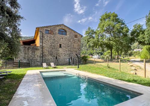 una casa con piscina frente a un edificio en Can Blanc de Montagut, en Montagut