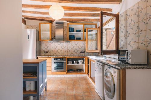cocina con nevera, lavadora y secadora en Can Blanc de Montagut, en Montagut