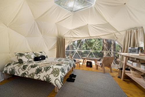 um quarto com uma cama numa tenda em Stay Wilder Sunshine Coast em Sechelt