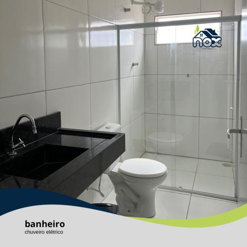 La salle de bains est pourvue de toilettes, d'un lavabo et d'une douche. dans l'établissement Nox Temporada - Flat 201 a 4km da Feira e Shopping Caruaru, à Caruaru