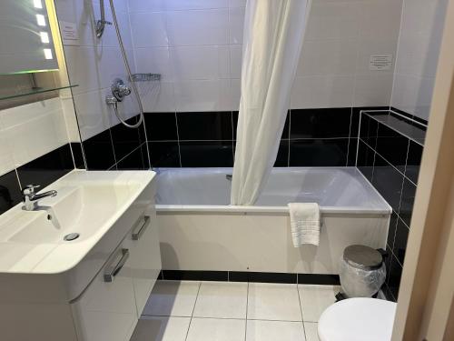 a bathroom with a white tub and a sink at The New Admiralty Hotel Ltd in Portland