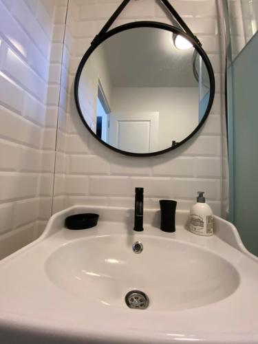 a bathroom sink with a round mirror above it at Cassis grande terrasse emplacement au top à 1 minute de la plage à pieds in Cassis
