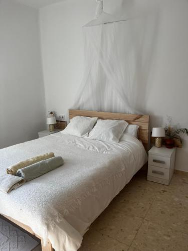 een slaapkamer met een groot bed met witte lakens en kussens bij Can Bastida in Cardona