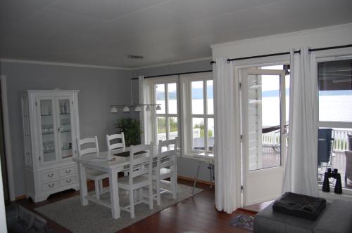 a dining room with a table and chairs and a balcony at Feriehus nede ved sjøen inntil 6 pers in Vestnes