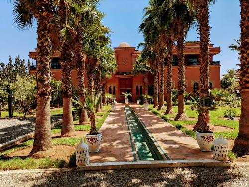 a courtyard with palm trees in front of a building at Villas Green in Marrakech