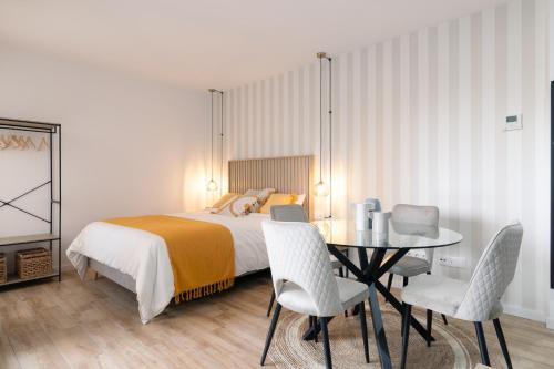 een slaapkamer met een bed en een tafel en stoelen bij DormForYou Ciudad de las ciencias Terraza in Valencia