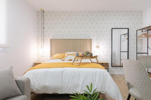 DormForYou Arena Standard في فالنسيا: غرفة نوم بسرير كبير مع بطانية صفراء