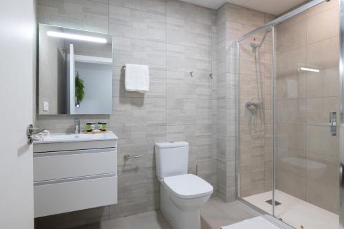 a bathroom with a toilet and a glass shower at DormForYou Arena Delux in Valencia