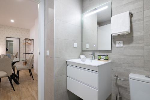 La salle de bains blanche est pourvue d'un lavabo et d'un miroir. dans l'établissement DormForYou Arena Standard, à Valence