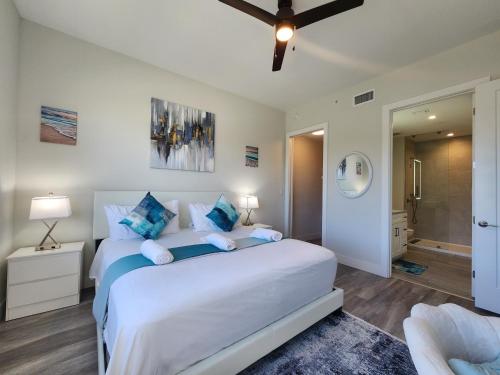 a bedroom with a large white bed with blue pillows at Lux place and cozy 3Beds 2Rooms enjoy life in WPB Gym, EV Station Nearby the downtown and beaches in West Palm Beach