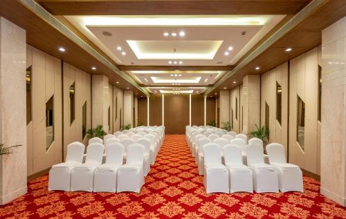 a row of white chairs in a room at The Orchid Jamnagar in Jamnagar