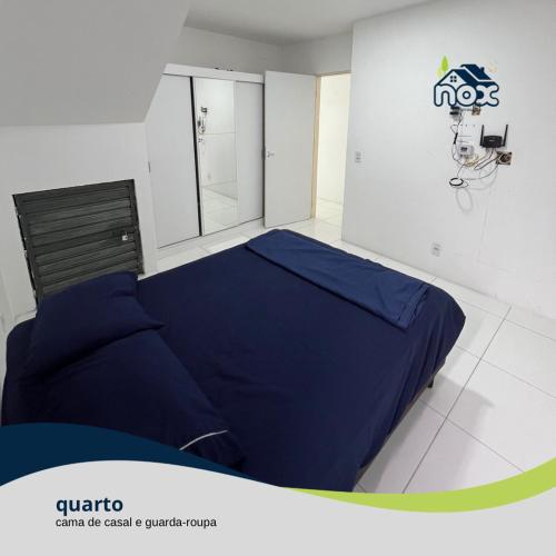 Nox Temporada - Flat 101 a 4km da Feira e Shopping Caruaru في كاروارو: غرفة نوم بسرير ازرق في غرفة