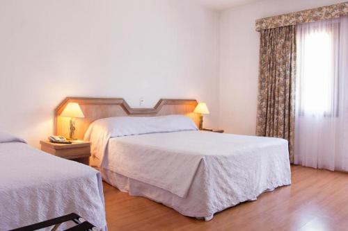 a hotel room with two beds and a window at Paradies Hotel Express in Jarinu