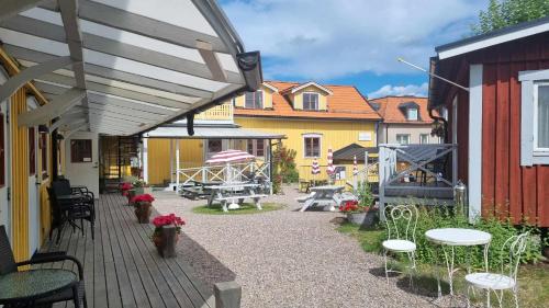 a patio with tables and chairs on a wooden deck at Epokgården in Öregrund