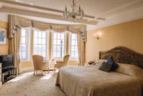a bedroom with a bed and a chandelier at Hotel Riviera in Sidmouth