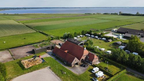 an aerial view of a farm with a building and a field at Camping Eefting in Rohel