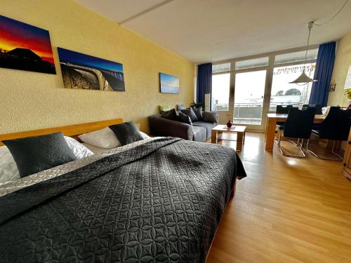 Burgtiefe auf Fehmarn にあるSuedstrand-Ferienwohnung-Suhrのベッドルーム1室(ベッド1台付)、リビングルームが備わります。