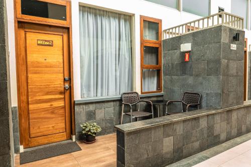 a porch with two chairs and a wooden door at Taman Simalem Resort in Tongging