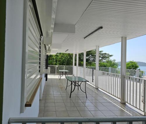 a balcony with a table and a view of the water at CHAUDIERE DE RÊVE in Le Vauclin