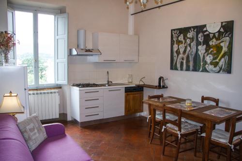 una cucina con divano viola e tavolo in una camera di Santa Croce Charme Apartment ad Arezzo
