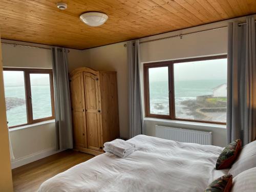 1 dormitorio con 1 cama y vistas al océano en The Coastguard House @ Tigh T.P., en Ballydavid