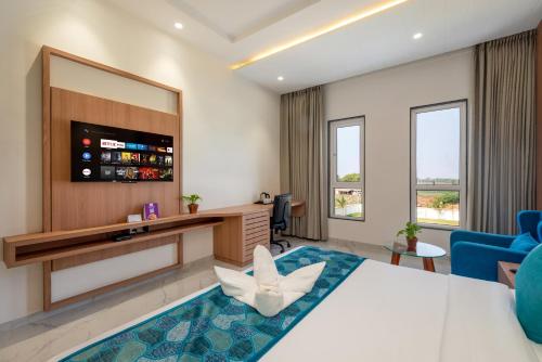 a hotel room with a large bed and a large mirror at The Orchid Jamnagar in Jamnagar