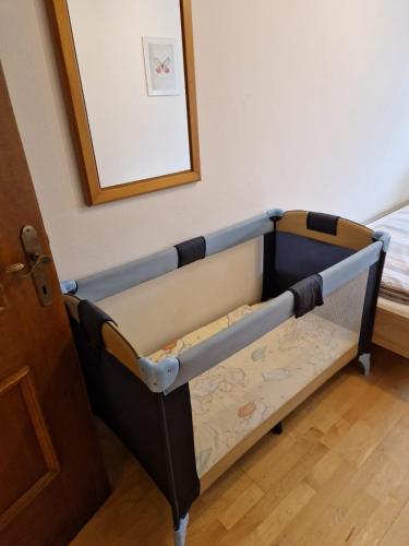 a small crib in a room with a mirror at Landhaus Gollner in Uderns