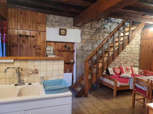 eine Küche mit einem Waschbecken und eine Treppe in einem Zimmer in der Unterkunft Le chalet in Vertamboz