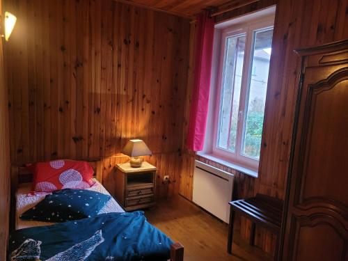 ein kleines Schlafzimmer mit einem Bett und einem Fenster in der Unterkunft Le chalet in Vertamboz