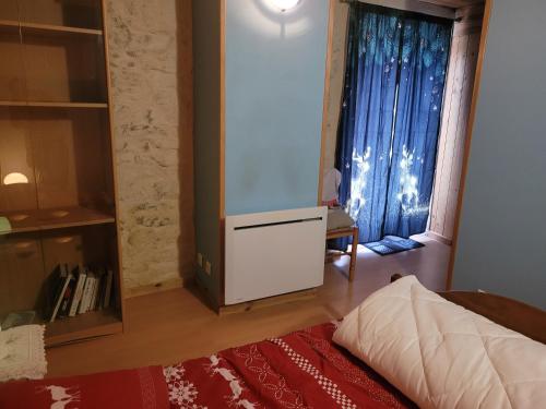 Zimmer mit einem TV, einem Bett und einem Fenster in der Unterkunft Le chalet in Vertamboz