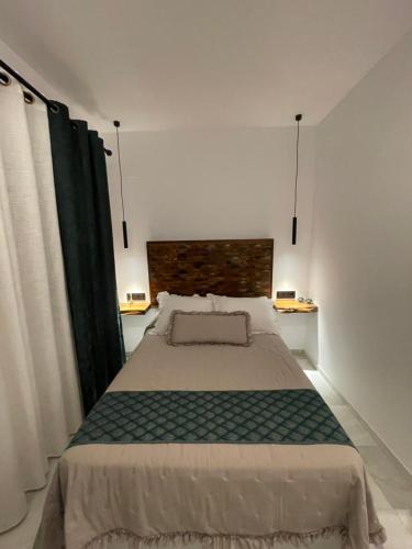 a bedroom with a large bed and two lamps at WISH SUITE PONCE DE LEON in Seville