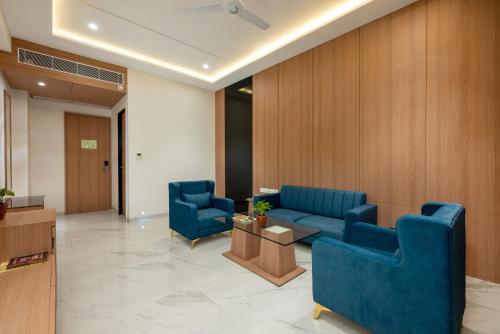 a lobby with two blue chairs and a table at The Orchid Jamnagar in Jamnagar