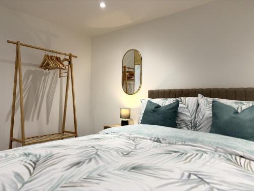 a bedroom with a bed with blue pillows and a mirror at Hardy Hideaway in Ulverston