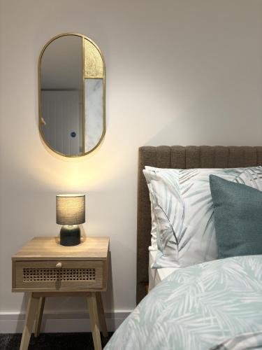 a bedroom with a bed and a table with a mirror at Hardy Hideaway in Ulverston