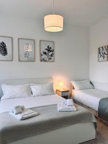 a bedroom with two beds with towels on them at Villa Noga Rooms in Selargius