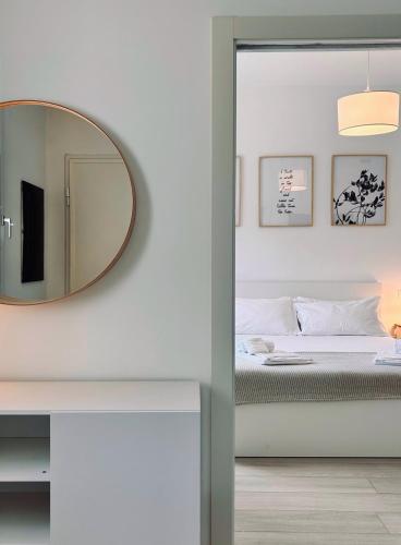 a bedroom with a mirror and a bed at Villa Noga Rooms in Selargius