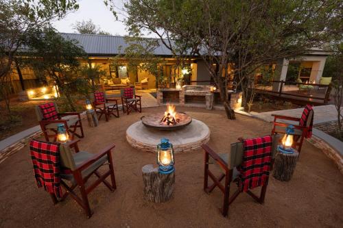 a fire pit with chairs and a table with candles at Africa House in Hoedspruit