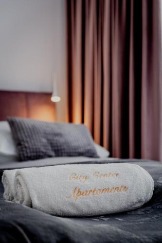 a towel sitting on top of a bed at Apartamenty Cicha - bezpłatny parking in Krynica Zdrój