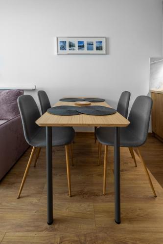 a dining room table with four chairs around it at Apartamenty Cicha - bezpłatny parking in Krynica Zdrój