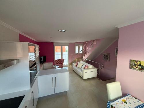 sala de estar con paredes de color púrpura y escalera en Casa Lalo, en Camariñas