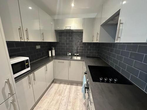 a kitchen with white cabinets and a stove top oven at Modern Studio Flat near Highbury & Islington station in London